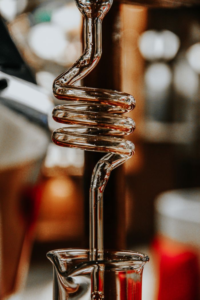 our-experience Detailed view of a glass pipe used in fermentation, highlighting its spiral design.