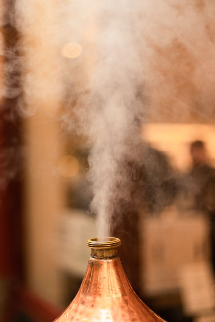 about-02 Close-up of steam rising from a copper tajine, evoking warmth and culinary art.